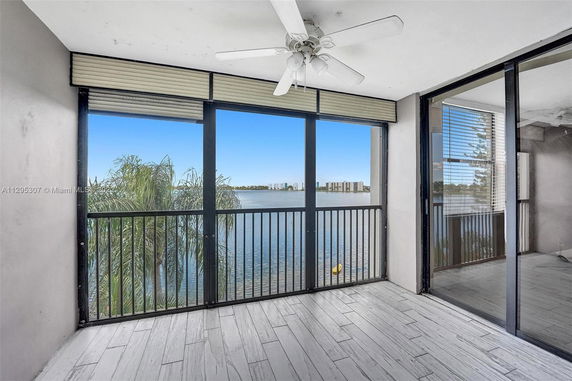 Panoramic view of a balcony overlooking a body of water with distant buildings.