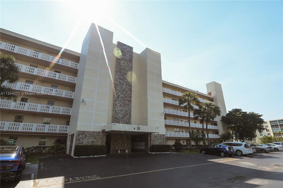 Front view of a multi-story residential building with stone and stucco elements.