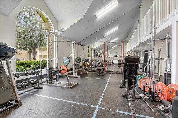 Interior view of a gym with exercise equipment and large windows.