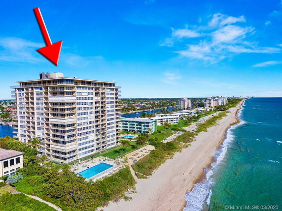 Panoramic view of a beachfront condominium with multiple balconies and a swimming pool.