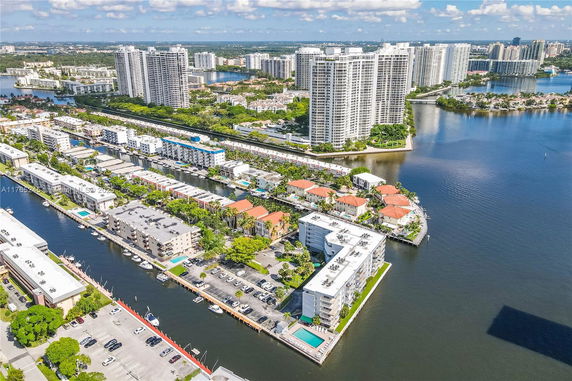 Panoramic view of a coastal cityscape with high-rise buildings and waterways.