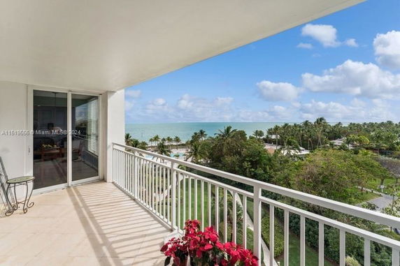 Balcony view overlooking the ocean and surrounding greenery.
