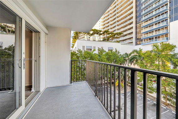 View from a balcony overlooking adjacent buildings and trees.