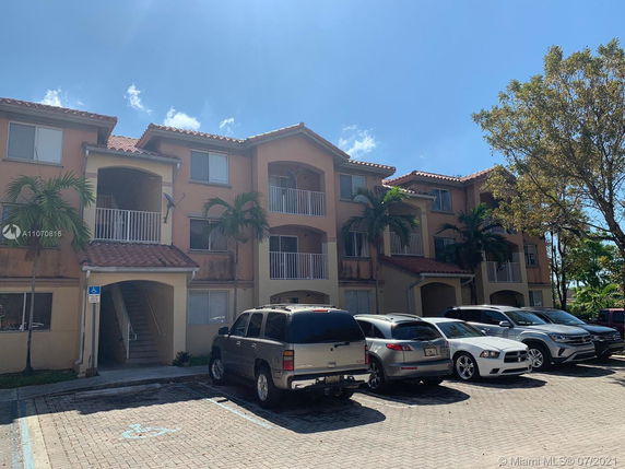 Front view of a three-story residential building with balconies.