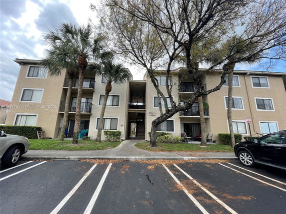 Front view of a three-story apartment building with balconies.