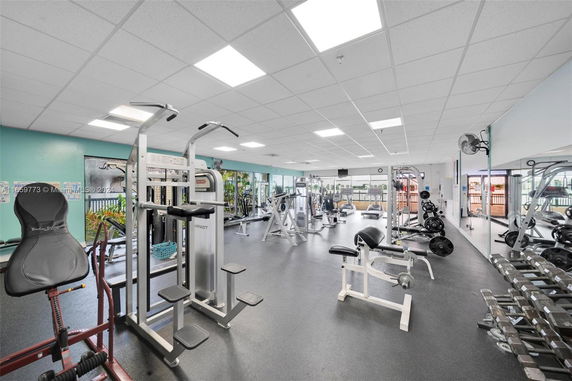 Indoor gym with various exercise equipment and weights.