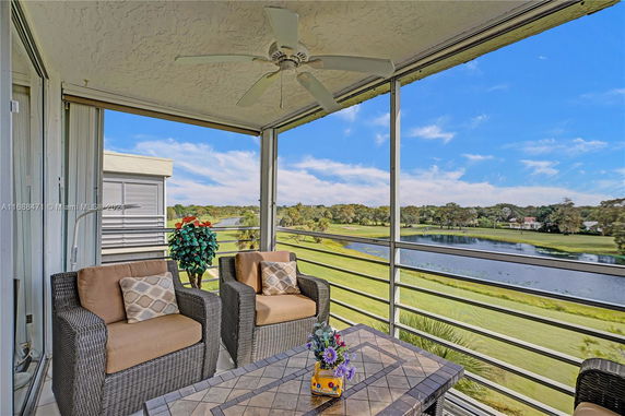 Outdoor seating area with a view of a landscaped area and water body.