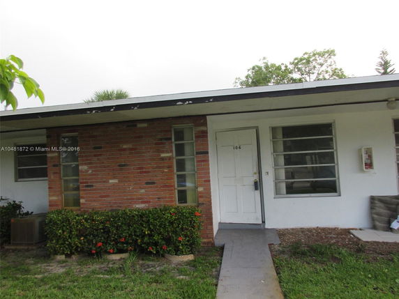 Front view of a single-story house with brick and white exterior.