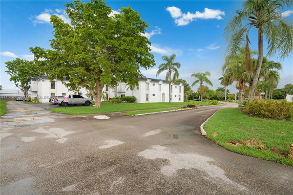 Outdoor area with parked cars near a white building.