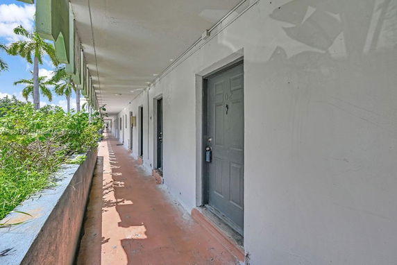 Exterior walkway of a building with several doors.