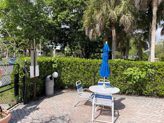 Outdoor patio area with a table, chairs, and an umbrella.