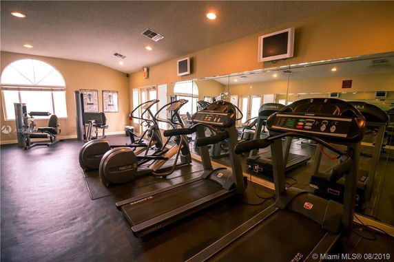 Interior view of a gym with treadmills, elliptical machines, and exercise equipment.
