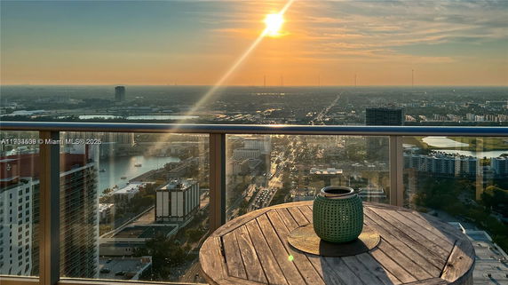 Panoramic view from a high-rise building at sunset, overlooking the city and waterfront.
