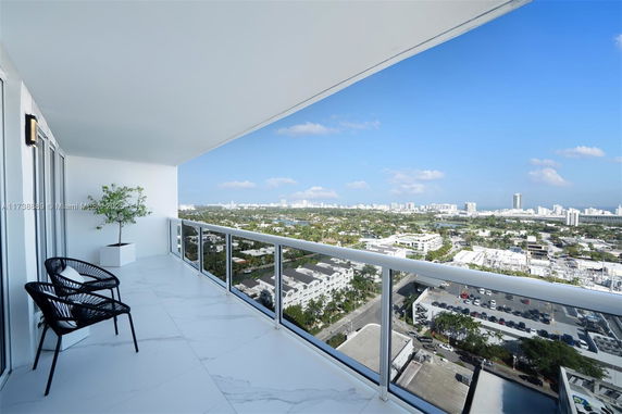 Panoramic view from a building balcony overlooking a cityscape.