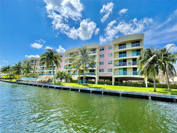 Front view of a multi-story waterfront apartment building with balconies.