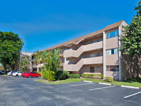 Front view of a three-story residential building with exterior staircases and balconies.