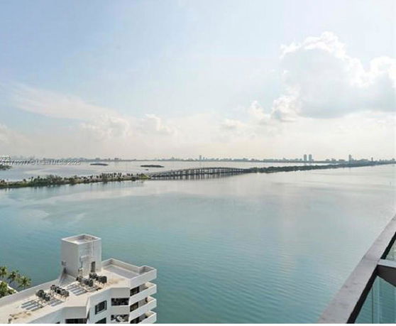 Panoramic view of a water body with a distant bridge and city skyline