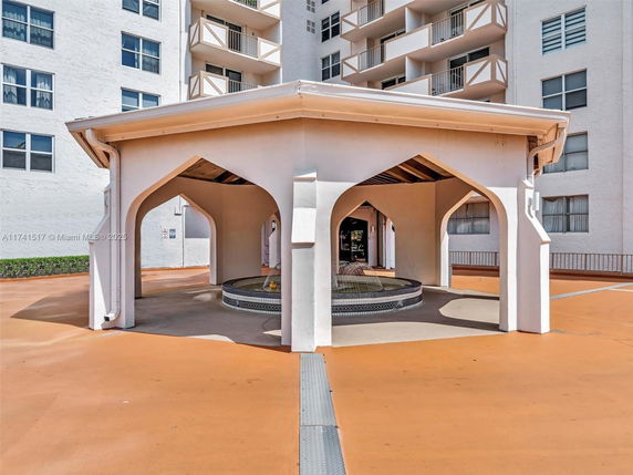 Outdoor view of a building with an arch-roofed gazebo structure.