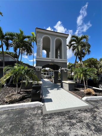 Front view of a two-story tower with arches and a tiled roof.