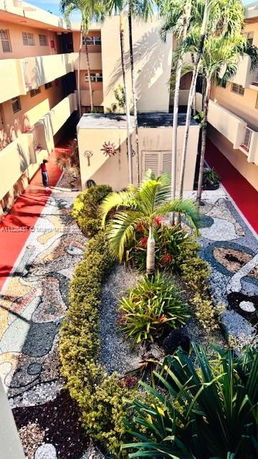 Courtyard view of an apartment complex with plants and decorative landscaping.