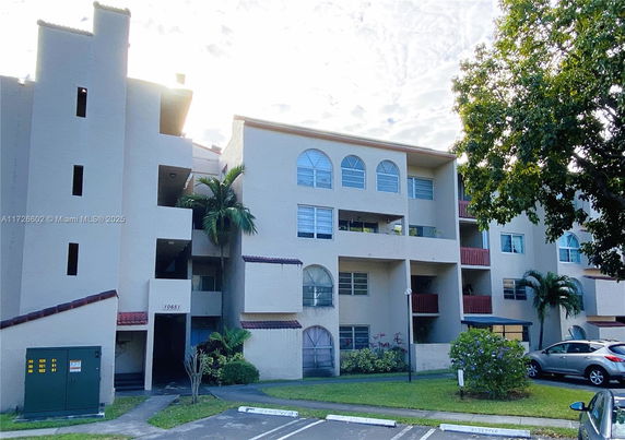 Front view of a multi-story building with arched windows and balconies.