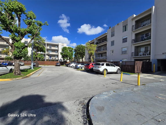 Outdoor parking area in front of a multi-story residential building.