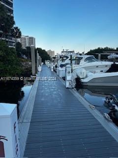Dock view with boats moored alongside, showing buildings in the background.