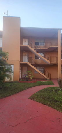 View of a multi-story apartment building with external staircases.