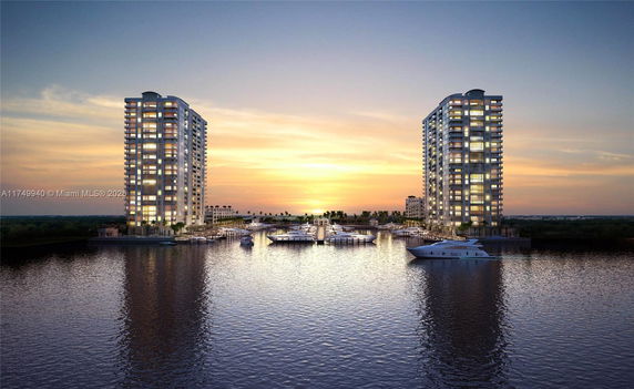 Front view of two high-rise residential buildings by a waterfront at sunset.