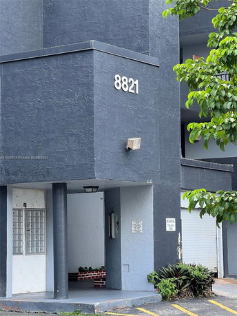 Corner view of a building with a number 8821 displayed on the wall.