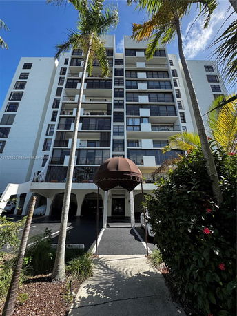 Front view of a multi-story apartment building with balconies.