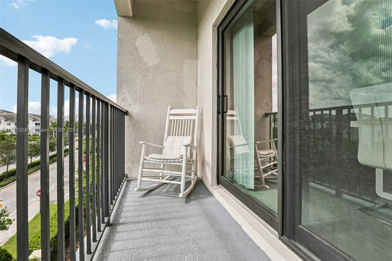 Balcony with a rocking chair overlooking the street.