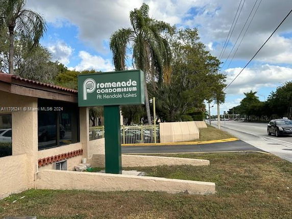 Front view of a condominium building with signage.
