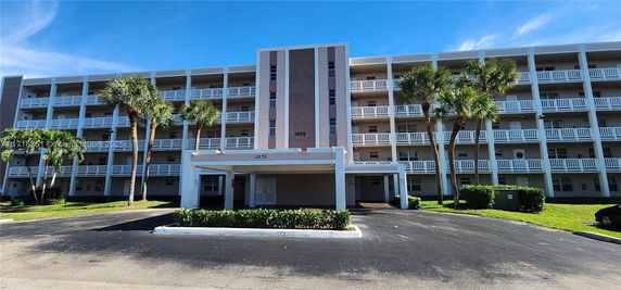 Front view of a multi-story residential building with balconies.