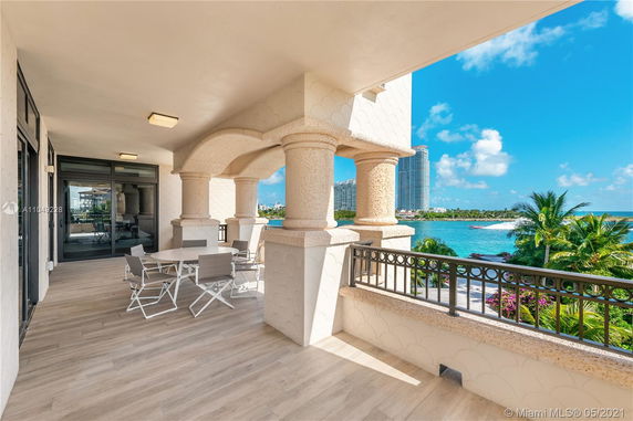 Terrace view showing columns and water with distant high-rise buildings.