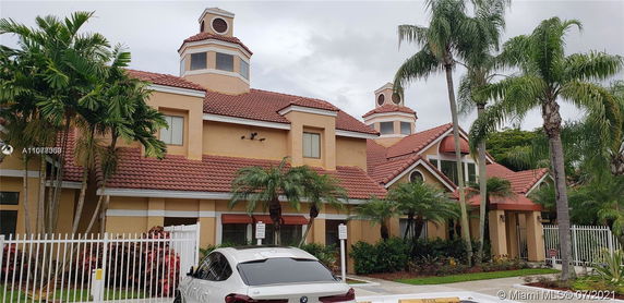 Front view of a building with red-tiled roof and tower-like structures.