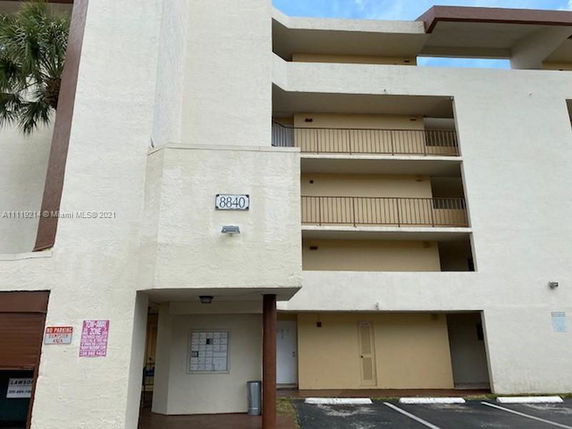 Front view of a multi-story apartment building with balconies.