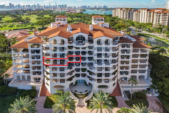 Aerial view of a large multi-story residential building with red-tiled roofs and multiple balconies.