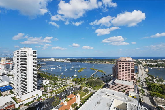 Panoramic view of high-rise buildings and waterfront with boats.