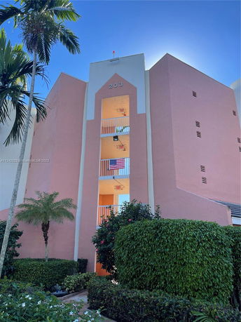 Front view of a multi-story building with pink and white exterior.