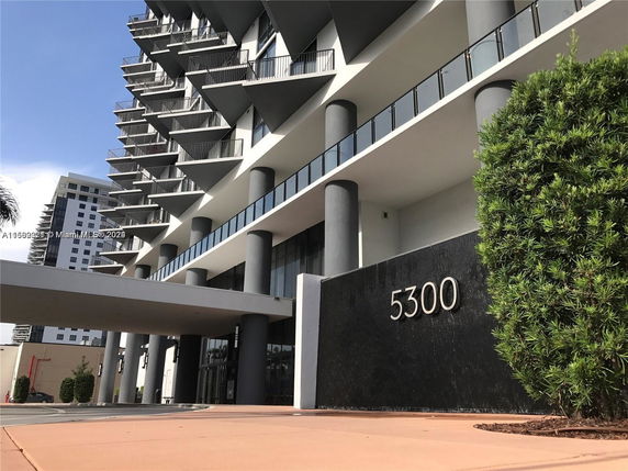 Front view of a modern multi-story building with balconies.
