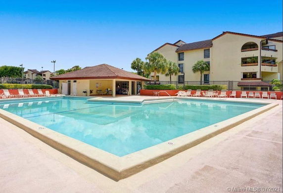Outdoor swimming pool area with adjacent residential buildings.