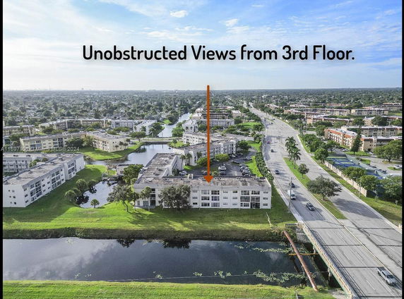 Aerial view of a residential area with multiple buildings, roads, and waterways.