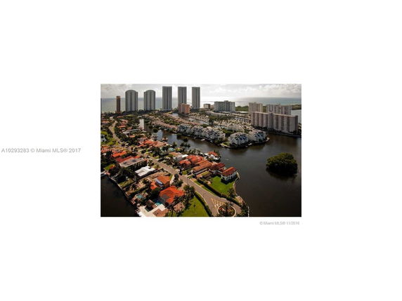 Aerial view of a coastal area with high-rise buildings and residential houses near waterways.