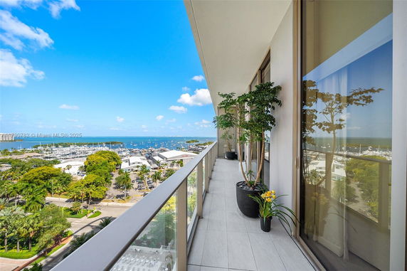 Balcony view with ocean and marina in the distance.