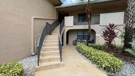Front view of a two-story residential building with a staircase leading to the upper level.