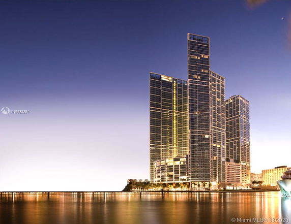Front view of a modern high-rise building by the water.
