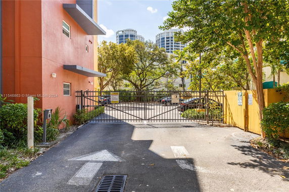 Gated outdoor parking area next to a building.