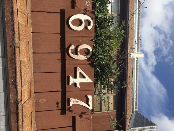 Front view of a house with a visible rooftop and address numbers.