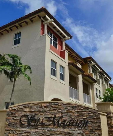 Front view of a multi-story building with decorative pillars and balconies.